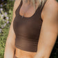 Up close photo of a brown tank top sports bra.  It is being worn by a white women with blonde short hair. 